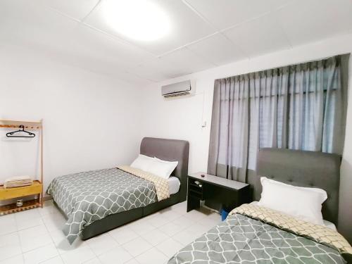 SS Ipoh Comfort Homestay - For Families and Groups في ايبوه: غرفة فندقية بسريرين ونافذة