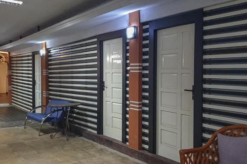 a room with two doors and a table and chairs at Rocky Guest House Syariah Mitra RedDoorz in Sungai Lutus