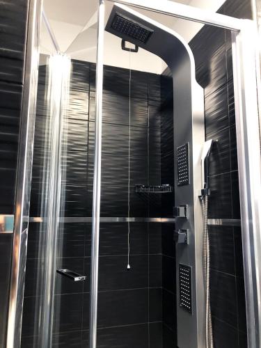 a shower in a bathroom with black tiles at Hotel Gioia in Florence