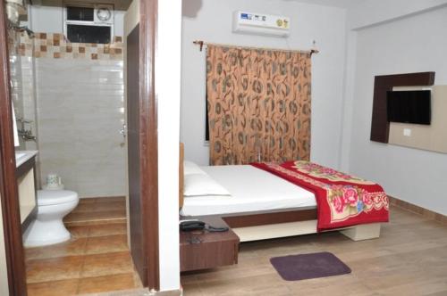 a bedroom with a bed and a shower and a toilet at Sea Facing Beach Resort in Mandarmoni