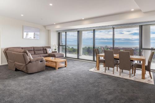 a living room with a couch and a table and chairs at The Cove 602 in Forster