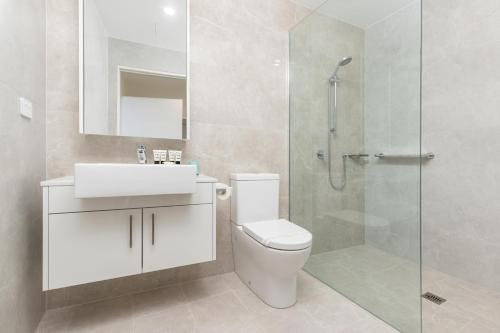a bathroom with a toilet and a glass shower at The Cove 602 in Forster