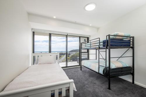 a bedroom with two bunk beds and a window at The Cove 602 in Forster