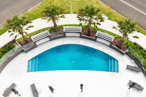 an overhead view of a swimming pool with chairs and palm trees at The Cove 602 in Forster