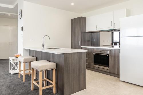 a kitchen with a counter and a sink and a refrigerator at The Cove 602 in Forster