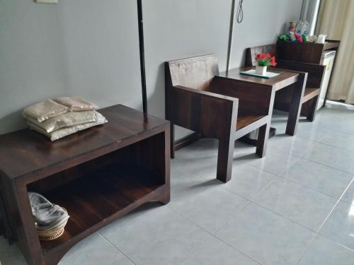 a room with wooden furniture and a table and a table and chairs at Platinum Place in Bangkok