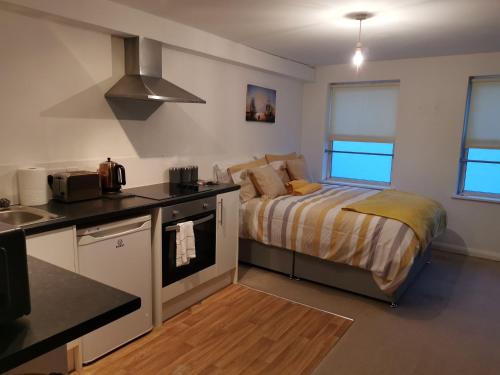 Una pequeña cocina con una cama en una habitación en Maidstone Heights II, en Maidstone