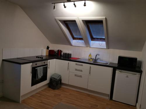 a kitchen with white cabinets and a black counter top at Unique Studio I - Private Studio with ensuite in Maidstone