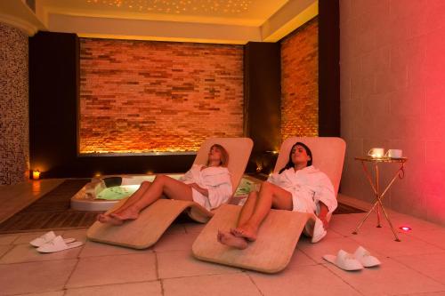 two women sitting in chairs in a room with a tub at Marina Holiday & Spa in Balestrate