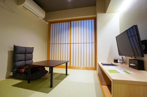 a room with a table and a chair and a desk at Hotel S-Presso Namba in Osaka