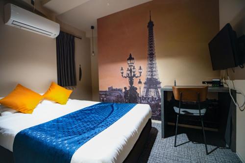 a hotel room with a bed and the eiffel tower at Hotel S-Presso Namba in Osaka