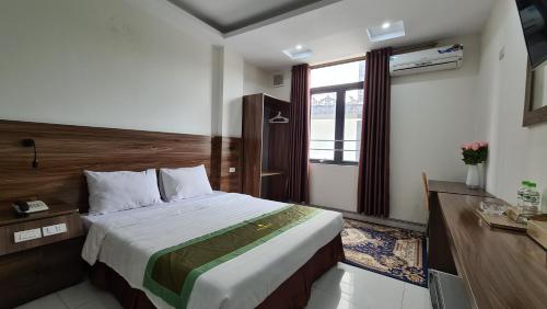 a bedroom with a large bed and a window at Thanh Hang Hotel near Emerald My Dinh in Hanoi