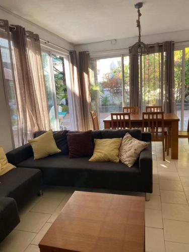 a living room with a black couch and a table at Oceanpride Complex in Flic-en-Flac