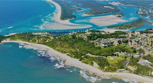 an aerial view of a beach and the ocean at THE DAVEY Luxury home in Nambucca Heads