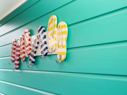 a group of ties hanging on a blue wall at Sandy Feet Retreat I Pet Friendly I 1 Min Walk to Beach in Currarong