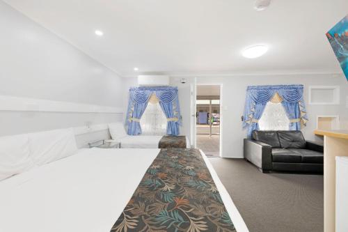 a bedroom with a bed and a couch at Best Western Bundaberg City Motor Inn in Bundaberg