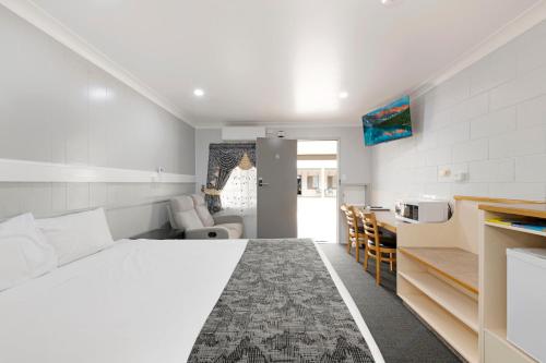 a white bedroom with a bed and a kitchen at Best Western Bundaberg City Motor Inn in Bundaberg
