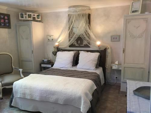 une chambre avec un grand lit à baldaquin dans l'établissement Lou Pero Mousco, à Saint-Paul-en-Forêt