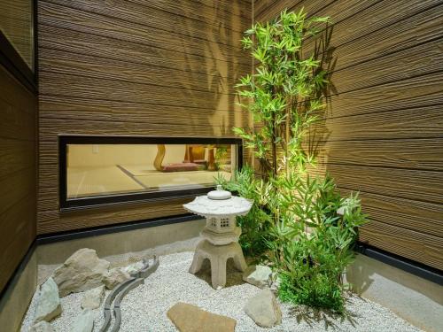 a japanese garden with a stone table and a tree at YADOYA Ryusenjicho in Tokyo