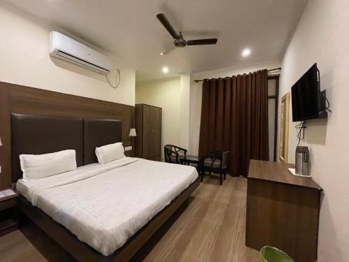a hotel room with a bed and a television at Tapasthali by Meera Hotels in Rishīkesh