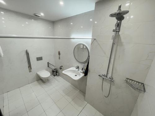 a bathroom with a toilet and a sink and a shower at Resident City Hotel in Almaty
