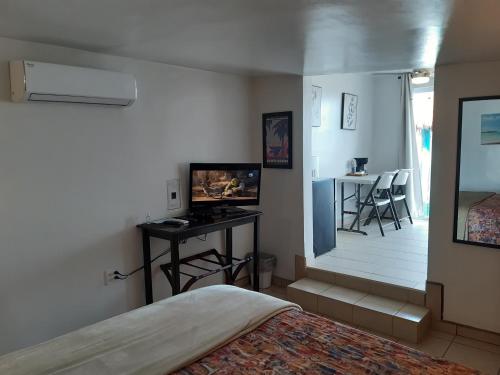 - une chambre avec un lit et une table avec une télévision dans l'établissement #7 Beach Front Private Room, à San Felipe