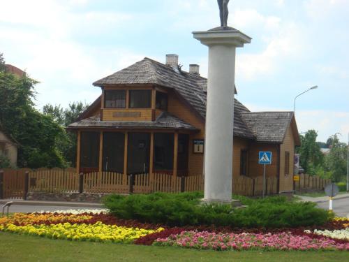 un edificio con una estatua delante de él con flores en Vila Marta, en Druskininkai