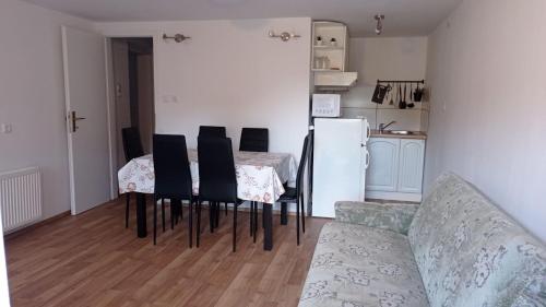 Apartma Jerman في كراجسكا غورا: غرفة معيشة بها طاولة وكراسي وثلاجة