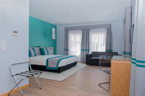 a bedroom with a bed and a couch at Alojamento do Zezere in Ferreira do Zêzere
