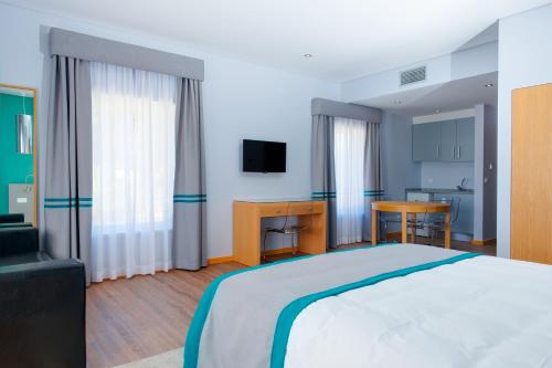 a bedroom with a large bed and a desk at Alojamento do Zezere in Ferreira do Zêzere