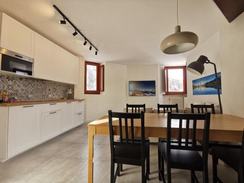 eine Küche und ein Esszimmer mit einem Tisch und Stühlen in der Unterkunft Aura Apartment - Ski In & Ski Out - Cerviniaholidays-com in Breuil-Cervinia
