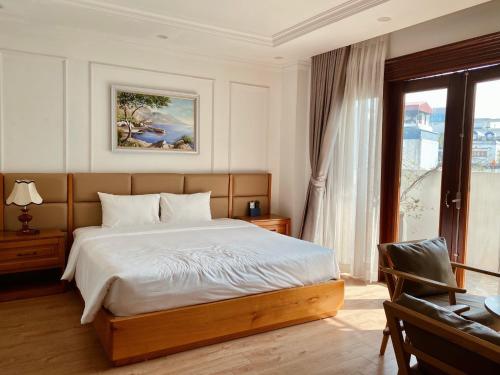a bedroom with a bed and a desk and a window at Libra Hotel Residence in Hanoi
