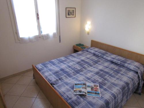 um quarto com uma cama com um edredão azul em Beach front apartment with sea view - Beahost em Bibione