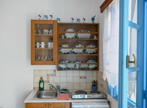 a kitchen with a sink and a cabinet with dishes at Blue Bliss in Ambrami