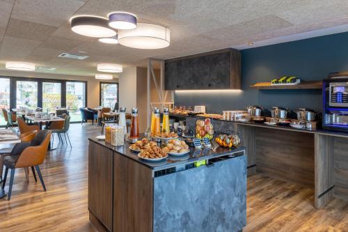 a kitchen with a counter with food on it at Best Western Plus Le Conquerant Rouen Nord in Bois-Guillaume