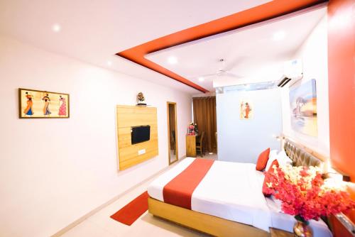 a hotel room with a bed and a tv at Hotel Grandeur-Near Mumbai International Airport in Mumbai