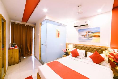 a bedroom with a large bed with orange walls at Hotel Grandeur-Near Mumbai International Airport in Mumbai