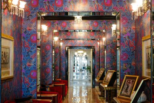 a hallway in a building with blue and red wallpaper at Rajmahal Palace RAAS in Jaipur