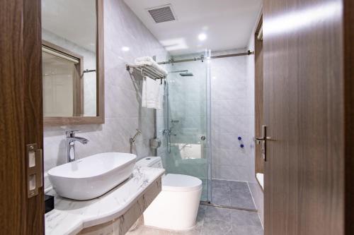 a bathroom with a sink and a glass shower at Sunshine Hotel Móng Cái in Móng Cái