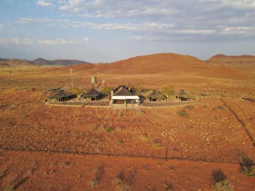 a group of huts in the middle of a field at Mountain View Villa in Maltahöhe