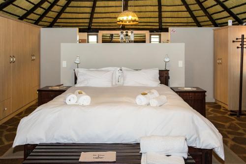 1 dormitorio con 1 cama con toallas en Mountain View Villa en Maltahöhe