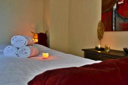 a room with a bed with towels and a candle on it at Logis Hôtel Le Calluna Restaurant La Flottille in Préfailles
