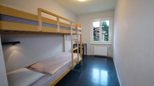 a room with two bunk beds and a window at Zermatt Youth Hostel in Zermatt