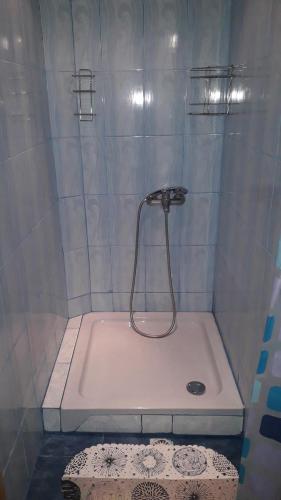 a shower with a white tub with a shower head at "Бджілка" і " Садиба для відпочинку" in Lyuta