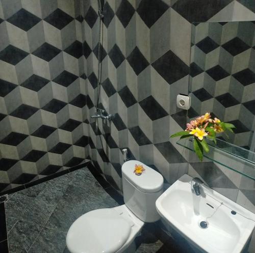 a bathroom with a white toilet and a sink at Rion Hostel Bogor in Bogor