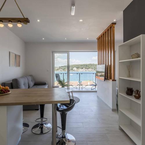 a kitchen and living room with a view of the ocean at Luxury apartments SKALINADA near beaches, Tisno - Dalmatia in Tisno