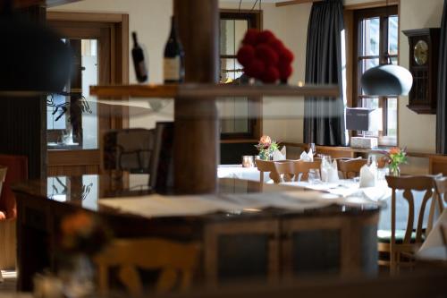a dining room with a table with flowers on it at Hotel Rössle in Alpirsbach