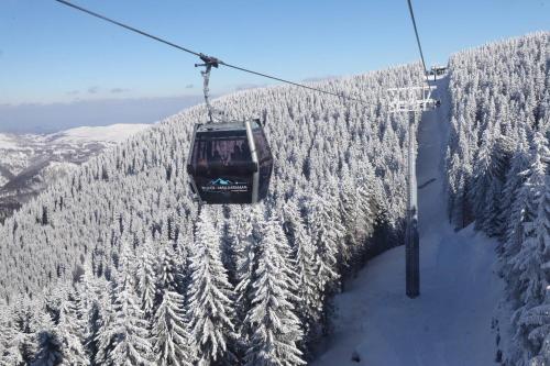a ski lift flying over a snow covered mountain at FOKA SPA APARTMANI 30 m from Junior in Brzeće