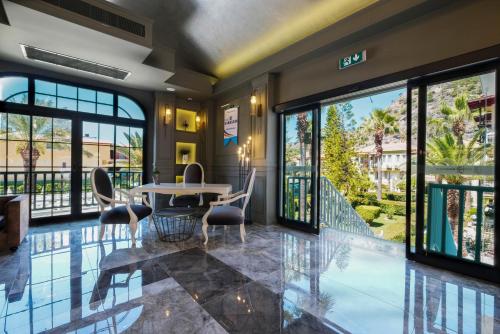 a lobby with a table and chairs and windows at Hotel Karbel Sun in Oludeniz