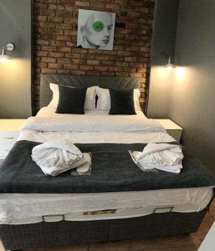 a bedroom with a large bed with a brick wall at Utarit Hotel in Istanbul